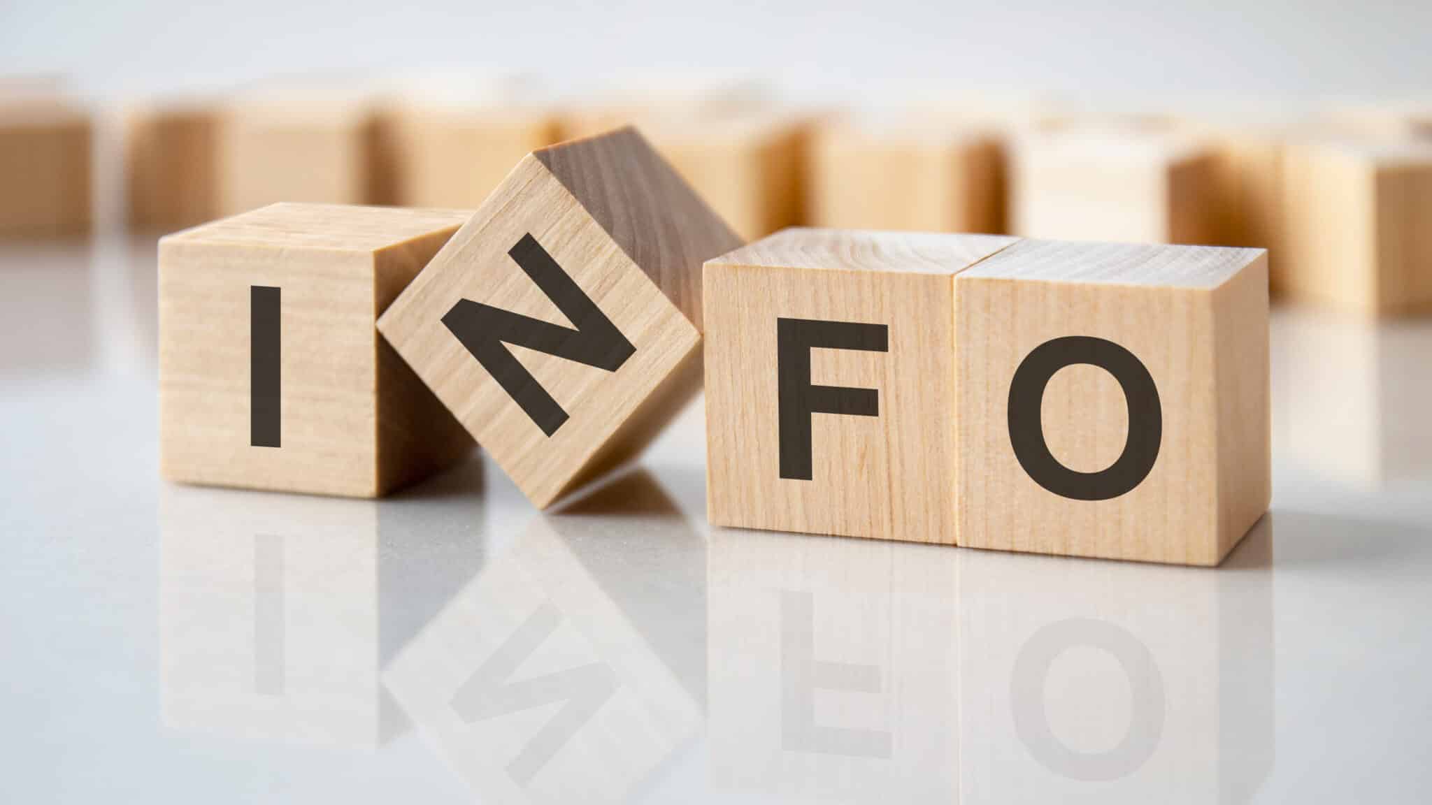 four wooden blocks with the letters info on the bright surface of a gray table, business concept